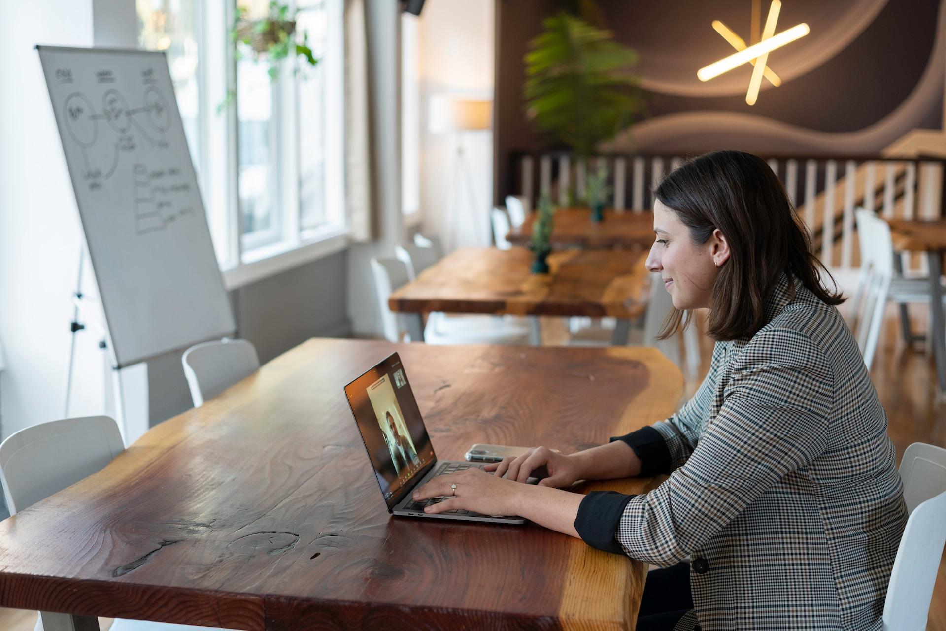 A woman in a grey jacket using a laptop.