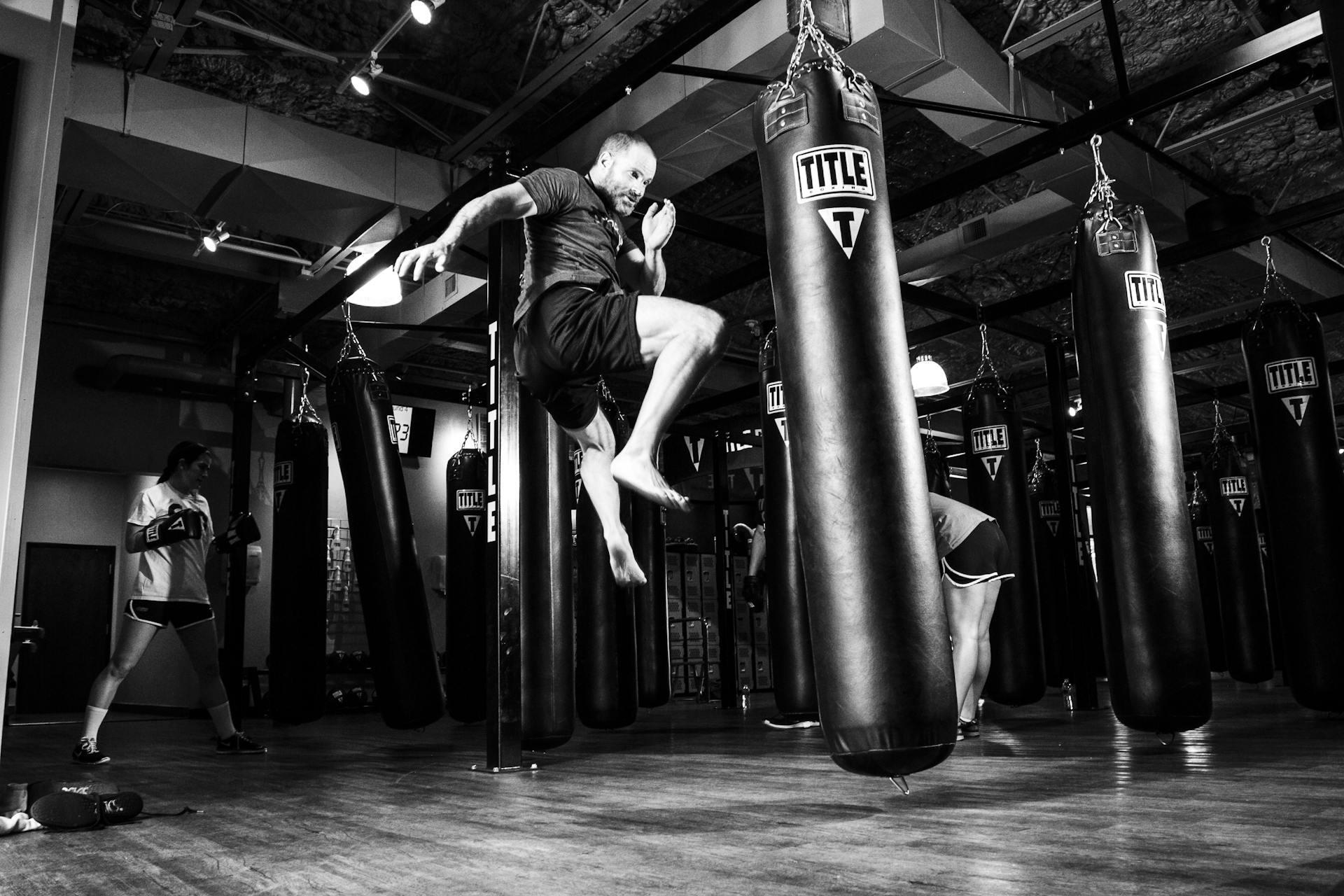 Man jumping to kick a punching bag