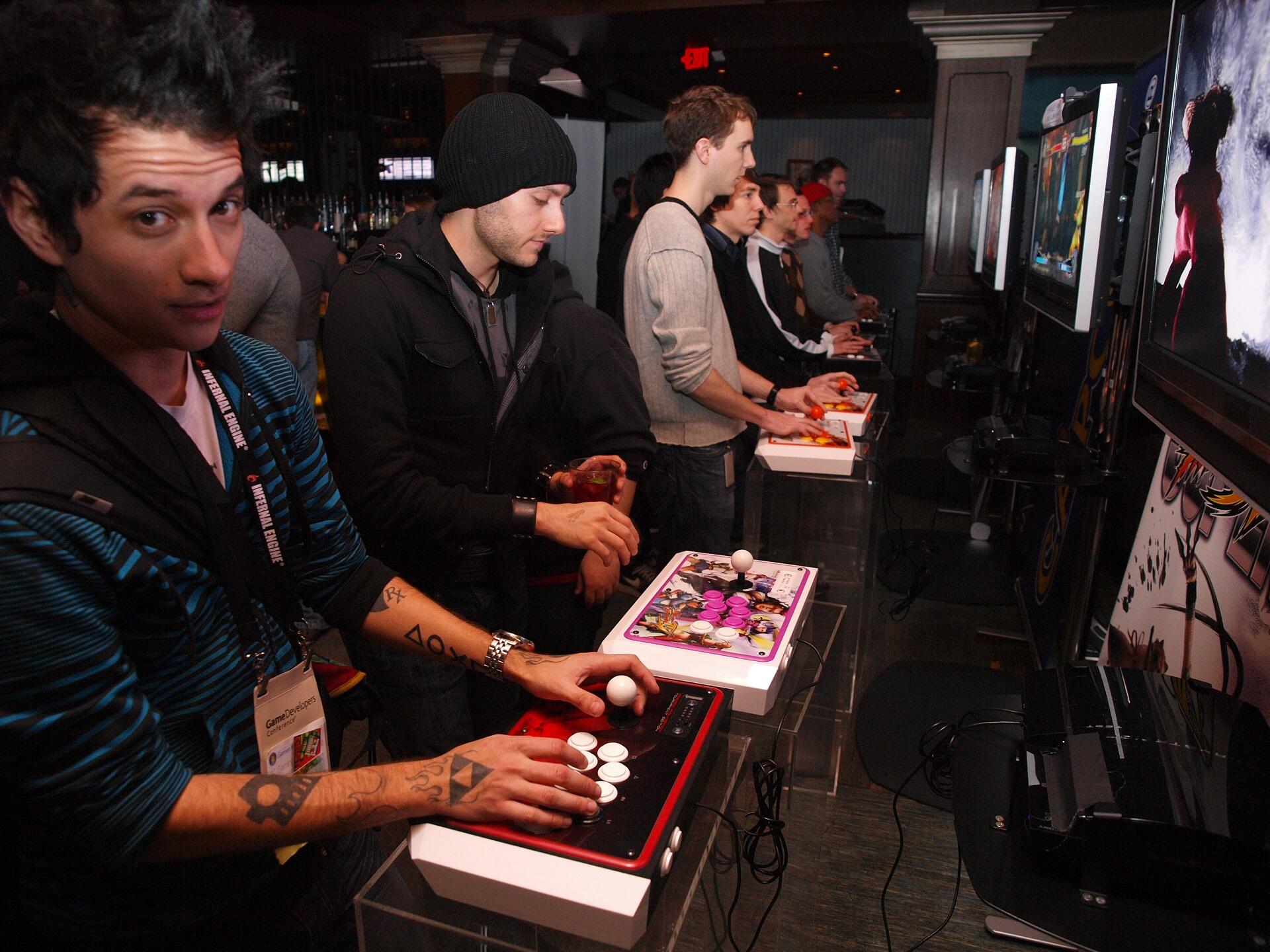 People in casual dress playing prototype video games.