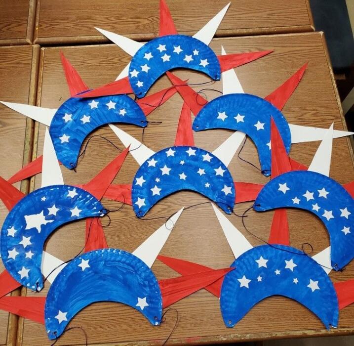 different versions of paper crowns in red, white and blue