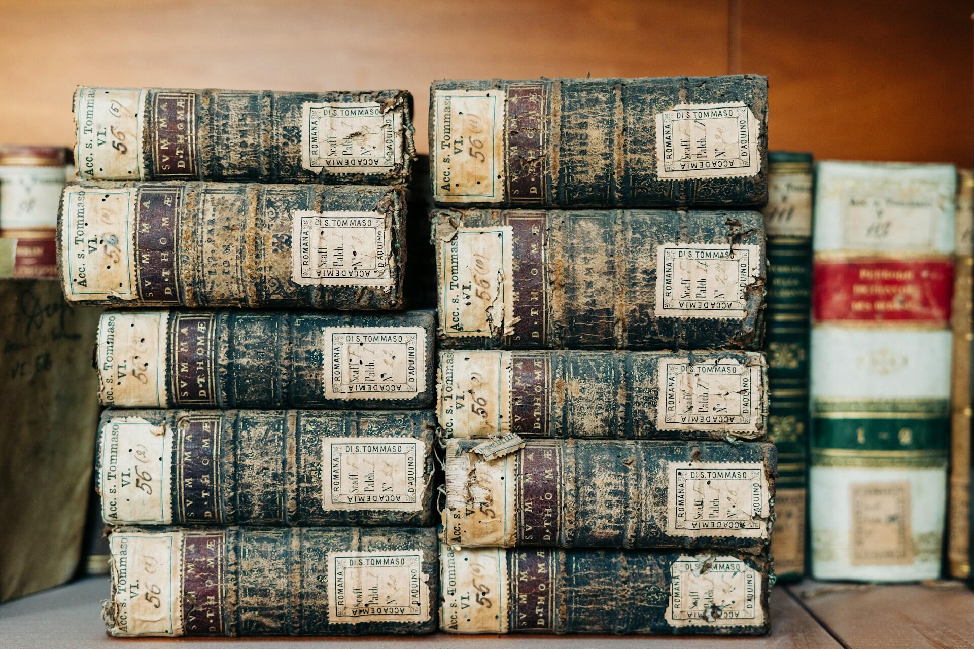 Ten old leather-bound books arranged in two stacks of five